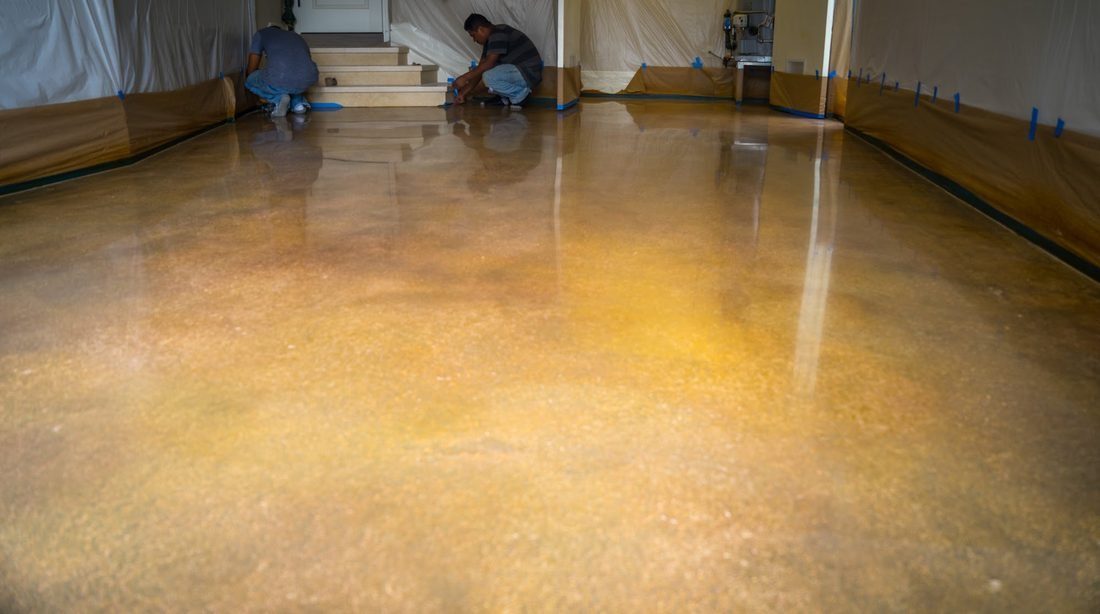 An installer working a coating across prepared concrete